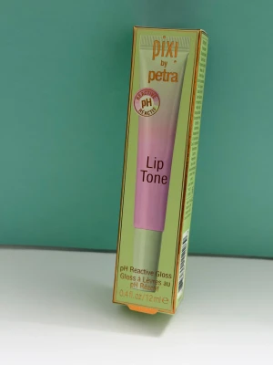 Pixi by Petra Lip Tone pH Reactive Gloss - Lip Tone pH Reactive Gloss från Pixi by Petra. Ett läppglans i tub som reagerar med dina läppars pH och ger en unik, glansig tint. Innehåller nyponfröolja och mangosmör för extra fukt. Förpackningen är ljusgrön med rosa detaljer, 12 ml.