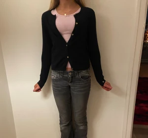 Svart kofta från Zara Girls - Svart, klassisk kofta från Zara Girls Winter Collection. Koftan har långärmad design, rund hals och knappar framtill. Mjuk stickad känsla som passar perfekt när det är lite kyligare. Enkel och stilren modell som är lätt att matcha med olika outfits.