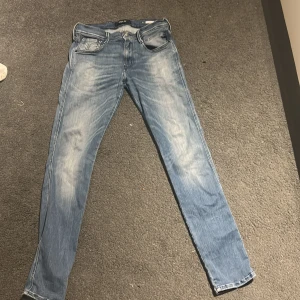 Replay ljusblå jeans, storlek 30/32 - Säljer ett par snygga Replay jeans i ljusblå färg och fadde. Jeansen har raka ben och broderade detaljer på bakfickorna. Passar dig som gillar en modern och avslappnad stil.
