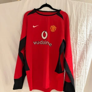Manchester United Ronaldo 7 långärmad tröja - Klassisk Manchester United fotbollströja med Ronaldo 7 på ryggen. Röd med svarta detaljer, broderat klubbmärke och Nike-logga framtill samt Vodafone som sponsor. Långärmad modell i lätt och ventilerande material.