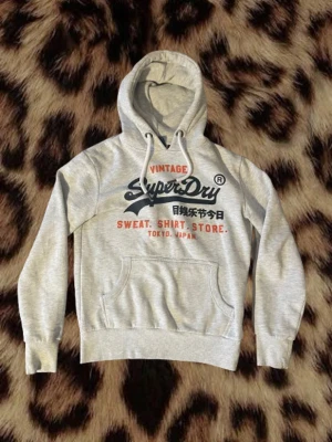 Grå Superdry hoodie - Asskön vintage superdry hoodie. Storlek S. Längd 62. Bredd 49.