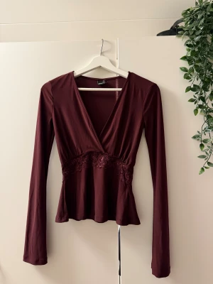 Vinröd omlottopp med spetsdetalj - Säljer denna vinröda omlottopp från Gina, endast provad! 