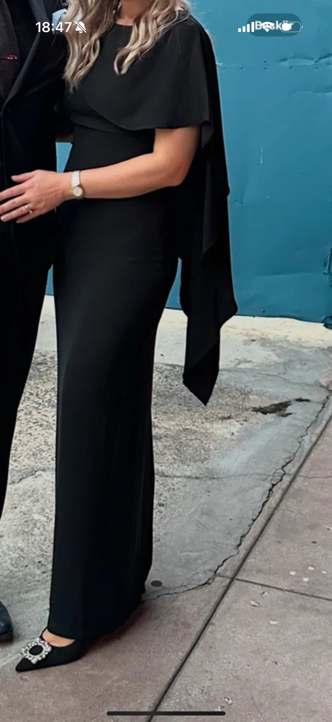 Svart långklänning med cape-detalj