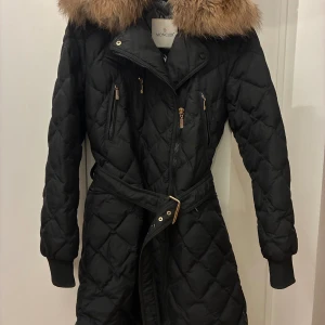 Moncler, jacka med avtagbar pälskrage  - Dunjacka från Moncler i knälång modell med avtagbar pälskrage. Storlek 3, vilket motsvarar ungefär 36-38.  Dragkedjan går att knäppa upp från båda hållen.  Flera fickor och skärp i midjan. Nypris runt 29,000kr.  Väldigt bra skick, men vissa mindre tecken på användning finns. Se bilder. Jag kan skicka alla bilderna eftersom alla bilder inte går att ladda upp i annonsen.  Kan hämtas hos mig på Kungsholmstorg eller skickas spårbart. 