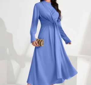 Ljusblå långärmad klänning - pris kan diskuteras!!  Oanvänd ljusblå långklänning med twistad detalj framtill i midjan. Klänningen har långa ärmar med breda manschetter och en hög halsringning. 