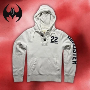 Vit hollister hoodie  - Vit hoodie knappar från hollister med svart tryck på ärmen och bröstet | Size S | Längd: 62cm Axelbredd: 44cm Armlängd: 62cm | Passar mellan 165-176 cm