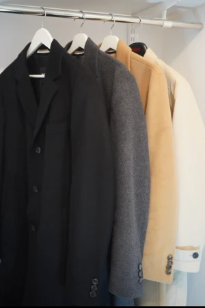 Svart rock från BOSS i full Kashmir - Svart rock från BOSS med klassisk krage och tre knappar framtill. Jackan är tillverkad i full Kashmir och har en stilren design. Perfekt för dig som vill ha en clean och tidlös look. Finns även i grått, beige och kamelbeige