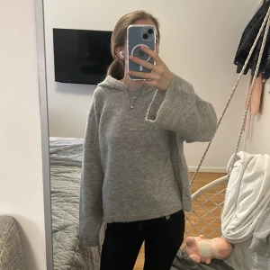 Grå stickad hoodie från Gina Tricot - Mysig grå stickad hoodie från Gina Tricot i storlek XS. Tröjan har huva, långa ärmar och en loose passform. Snyggt ribbad vid muddar och nederkant. köpt för runt 300kr pris kan diskuteras 