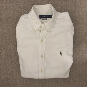 Vit skjorta från Ralph Lauren - Klassisk vit skjorta från Ralph Lauren, skjortan är i ett otroligt bra skick den är använd 2 gånger. Skjortans ny pris går för cirka 1500kr. Skriv och kontakta om du vill veta mer.