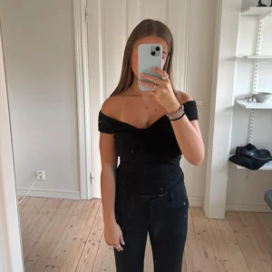 Svart omlott offshoulder topp - Svart topp med omlott-detalj och offshoulder