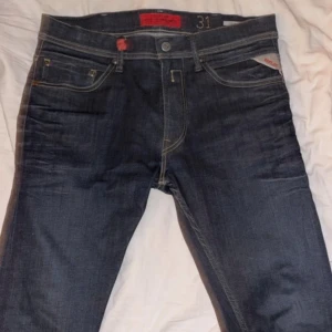 Replay Jondrill jeans mörkblå 31/32 - Snygga Replay Jondrill jeans i mörkblå tvätt med klassiska kontrastsömmar och fem fickor. Modellen har rak passform och normal midja, med Replay-logga på fickan och etikett bak. Perfekt för dig som gillar stilrena jeans med coola detaljer. pris går att diskutera