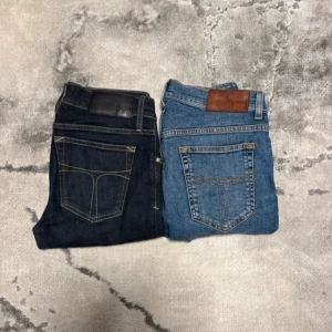 Tiger of Sweden jeans  - Säljer två par klassiska T/G jeans, ett par i ljusblå tvätt och ett par i mörkblå denim. Båda har femficksdesign, kontrastsömmar och läderpatch bak i midjan. Perfekta för dig som gillar tidlös stil och vill ha jeans med snygg passform. Storlek: 29/32 och 30/32