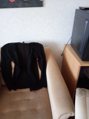 Svart stickad kofta med hålmönster - Säljer en svart stickad kofta med snyggt hålmönster längs hela framsidan. Koftan har långärmade ärmar och är perfekt att slänga över en t-shirt eller linne. Enkel och stilren design som passar till många olika outfits.