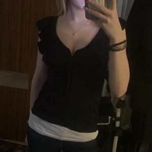 Svart top med volang  - Svart top med volang storlek S