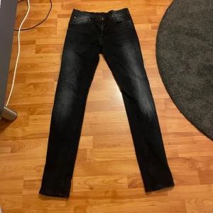 Nudie Jeans  - Snygga Tape Ted jeans från Nudie Jeans i blåsvart färg med diskret tvättad look. Modellen har klassisk femficksdesign, dragkedja och knappstängning. Tillverkade av 99% ekologisk bomull och 1% elastan för skön stretch och passform.