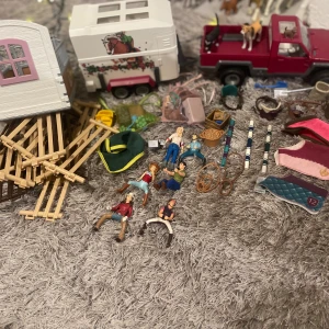 Schleich hästgård och figurer - Stor samling Schleich hästfigurer, stall, hästtransport, tillbehör och ryttare. Ca 40 hästar i olika färger och raser, flera ryttare, staket, hinder och smådetaljer. Allt i gott skick, perfekt för lek eller samlare. Några smådelar kan ha lätt slitage.