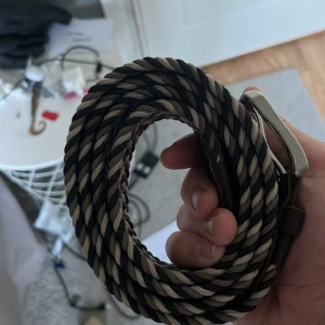 Flätat svart och beige bälte ifrån Jack and Jones - Snyggt flätat bälte i svart och beige med silverfärgat spänne. Bältet har en grov, tvinnad design som ger en cool och modern look. Perfekt för att lyfta din outfit med lite extra edge. Passar till jeans eller chinos och är lätt att justera. Ifrån Jack and Jones pris att diskutera helt ny