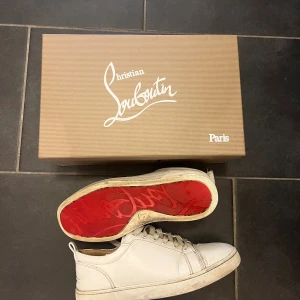 Vita sneakers från Christian Louboutin - Säljer ett par vita loubs som är perfekta för vinter då dem inte är i mocka som kan förstöras, det är skinn. Dem har små deffekter men inte någonting som påverkar hur sköna dem är eller som synd vid användning, se bild 4. Alla tillbehöret med kommer! Hör av er om ni har frågor eller vill ha mer bilder.