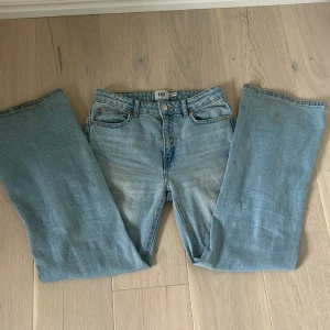 Ljusblå slitna jeans från 157 - Ljusblå jeans med raka ben och slitningar på båda knäna från 157. Klassisk femficksmodell med normal passform och hög midja. Jeansen har en avslappnad vibe och är tillverkade i bomullsdenim.
