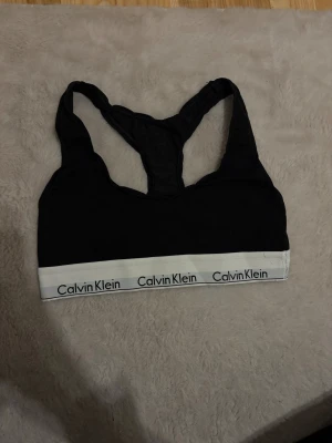 Topp Calvin klein - Calvin Klein topp. Använd få gånger men texten har lyckats suddas ut i tvätten. Utöver det toppen!🙌🏼