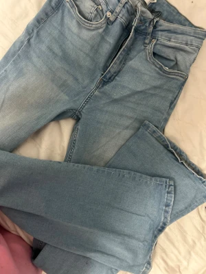 ljusblå bootcut jeans - Ljusblå  jeans med klassisk bootcut passform och raka ben. Jeansen har fem fickor, dragkedja och knappstängning. Tillverkade i mjukt jeanstyg med snygg tvättad look och detaljerad söm på bakfickorna.