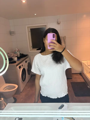 Vit blus med struktur från lager 157 - Säljer en vit blus från lager 157 i storlek M. Toppen har en cool strukturerad yta, rund hals och korta ärmar. Nederkanten har en vågig detalj som ger extra stil. Perfekt för dig som gillar enkla men snygga plagg!