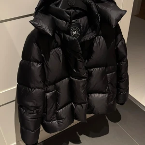 Monel jacka - Svart pufferjacka från Monel med stor, mysig luva. Modellen heter Lucie Boxy. Säljer den då jag tycker att den är för stor för mig. Ser i princip helt ny ut förutom lite noppriga muddar, se bild. Pris kan diskuteras💕 Nypris: 5500kr