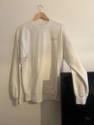 Vit sweatshirt från Vailent i M - Vit sweatshirt från Vailent i storlek M. Tröjan har rund hals, ribbade muddar och ett diskret tryck på bröstet. Tillverkad i mjuk bomull med relaxed passform och långa ärmar. Perfekt för chill dagar och enkel att matcha med jeans eller joggers. Helt ny. Köpt på carlings.