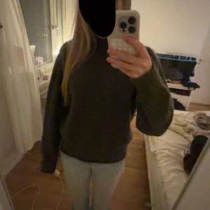 Mörkgrön polotröja från Neo Noir - Säljer en mörkgrön polotröja från Neo Noir med hög krage och långärmad passform. Tröjan är stickad och har en loose fit som ger en chill och avslappnad vibe. Perfekt för att hålla sig varm under kyliga dagar.