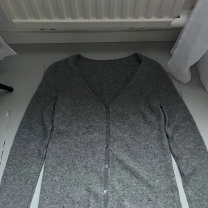 Grå kashmirkofta från La Redoute - Grå kofta från La Redoute. Klassisk v-ringning och små fickor framtill. Skriv vid frågor eller intresse. 