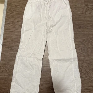 Vita Linnebyxor  - Säljer ett par vita linnebyxor från Gina Tricot i storlek XS. Byxorna har resår i midjan och snörning framtill. Aldrig använda. 