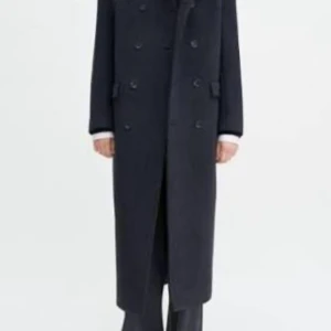  Filippa K Dubbelknäppt rock i ull  - Säljer en stilren och lång mörkgrå rock i ull från Filippa k. dubbelknäppning och klassisk krage. Rocken har raka ärmar, två fickor med lock, den är oversized nypris 7900:-.( Utnyttjade en nykundsrabatt därav priset på bild 5)