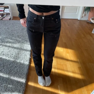 Svarta Levis jeans straight fit - Säljer ett par svarta Levis jeans med klassisk rak passform och hög midja. Jeansen har fem fickor, silverfärgad knapp och Levis-lapp bak i midjan. Perfekta för dig som gillar en tidlös och clean look.