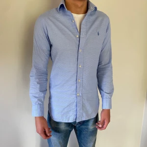 Ljusblå Ralph Lauren skjorta - Säljer denna riktigt snygga Ralph Lauren skjorta i subtilt rutigt mönster. Skjortan är i nyskick och sitter som en större S eller mindre M. Jag på bilden är 181cm