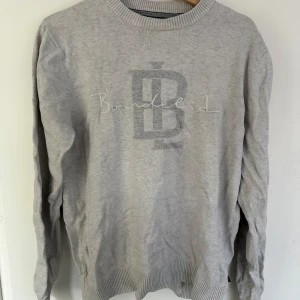 Grå tröja från Bondelid - Säljer en stilren grå tröja från Bondelid i storlek M. Tröjan har ett diskret tryck på framsidan med Bondelids logga. Den är långärmad och har ribbade muddar vid ärmslut och nederkant. Perfekt för en avslappnad stil!