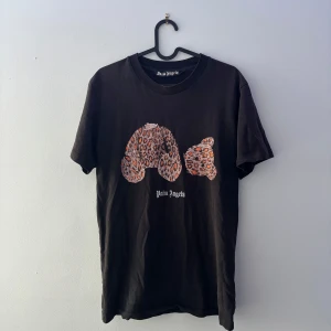 Palm Angels svart t-shirt med leopardtryck - Svart t-shirt från Palm Angels med ikoniskt avhugget nalletryck i leopardmönster på bröstet och stor vit logga på ryggen. Klassisk passform, rund hals och korta ärmar. Tillverkad i mjuk bomull för skön känsla. OBS! Defekter, hör av er vid frågor 👍🏼