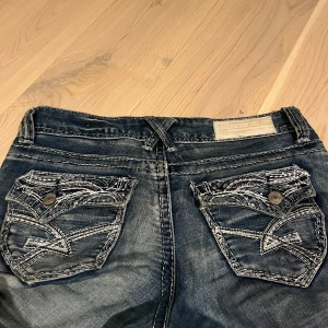 Vintage lowwaist bootcut jeans - Ett par bootcut jeans med coola fickor och lite slitningar. Midje måttet är 39cm och Innebens längden är ca 80cm. Skriv för fler frågor!💕💕