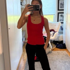 Röd ribbad linnetopp - Snygg röd ribbad linnetopp med breda axelband och rundad urringning. 