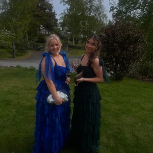 Balklänning  - Supersnygg mörkgrön långklänning med flera lager volanger och breda axelband med rosett-detaljer. Klänningen har en romantisk och flowy känsla, perfekt för bal!  Jag är 162 med 4 cm klackar var längden perfekt! Endast använd en gång 