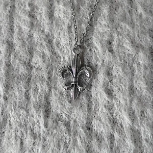 Essential Fleur - Stainless steel fleur-de-lis necklace with a 2 x 1.3 cm minimalist pendant on a 50 cm chain. Elegant, versatile, and unisex.