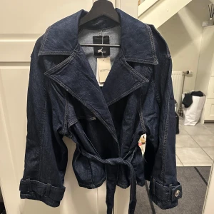 Mörkblå jeans trenchcoat  - Snygg mörkblå trenchcoat i jeansmaterial från Mango. Helt slutsåld, storlek XS, med lapparna kvar