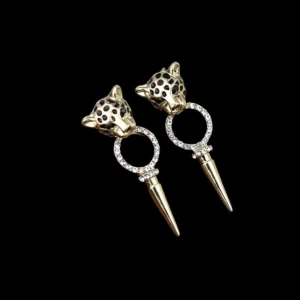 Leopardmönstrade örhängen med strass - Coola örhängen i guld med leopardhuvuden och svarta prickar. Ringen under huvudet är täckt av glittrande strass och avslutas med en spetsig guldpendel. Perfekt för dig som vill sticka ut med ett djurinspirerat smycke.