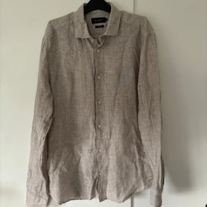 Riley grå linneskjorta  - Linneskjorta av grym kvalite från Riley och storlek M säljes. Grå och ursnygg passform perfekt för alla tillfällen. Tveka inte vid minsta fråga eller fundering🤩