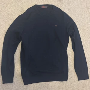 Mörkblå merinoullströja från Morris - Snygg mörkblå tröja från Morris i mjuk merinoull. Klassisk rund hals och diskret Morris-logga broderad på bröstet. Långärmad och med ribbade muddar vid hals, ärmslut och nederkant. Perfekt för dig som gillar stilrena och bekväma plagg. Hör gärna av dig för fler bilder!😁