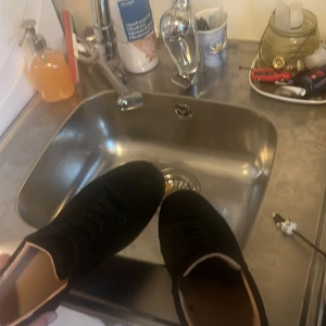 Svarta sneakers med snörning - Säljer ett par helsvarta sneakers med klassisk design och snörning. Skorna har rund tå och platt sula, vilket gör dem riktigt bekväma. Utsidan är i textil och insidan är ljusbeige. Perfekta för dig som gillar stilrena och enkla skor.