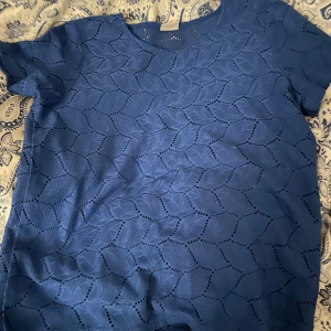 T-shirt - Blå tunn t-shirt med hål från Jacqueline de Yong med löv mönster. Köpt på second hand men satt inte som jag hade hoppats. Storlek S men ganska tight. Tvättar allt innan, skriv för mer bilder eller om du har några frågor.💞