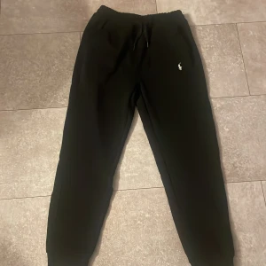Svarta mjukisbyxor från Polo Ralph Lauren - Svarta mjukisbyxor från Polo Ralph Lauren med klassisk logga broderad på vänster ben. Helt nya och i bra skick. Passar inte mig.