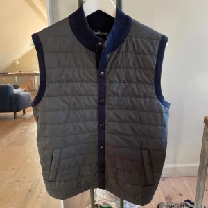 Barbour dunväst  - Barbour dunväst perfekt för hösten. Storlek L. Passar 182-192 typ. Skick 9/10. Hör av dig vid frågor eller om det behövs mer bilder. MVH/Bpluggen