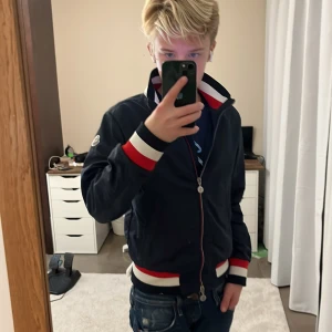 Moncler vindjacka med röd/vita detaljer - Snygg marinblå vindjacka från Moncler tyvärr för liten för mig nu storlek 14 från vongreven closet
