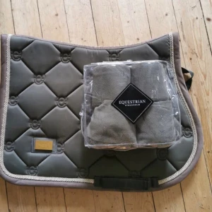 Equestrian Stockholm schabrak+lindor - Hoppschabrak med tillhörande lindor från Equestrian Stockholm i färgen Golden Olive. Storlek ponny. Lindor fullånga men avklippta något för att bli lite kortare och passa ponny. 